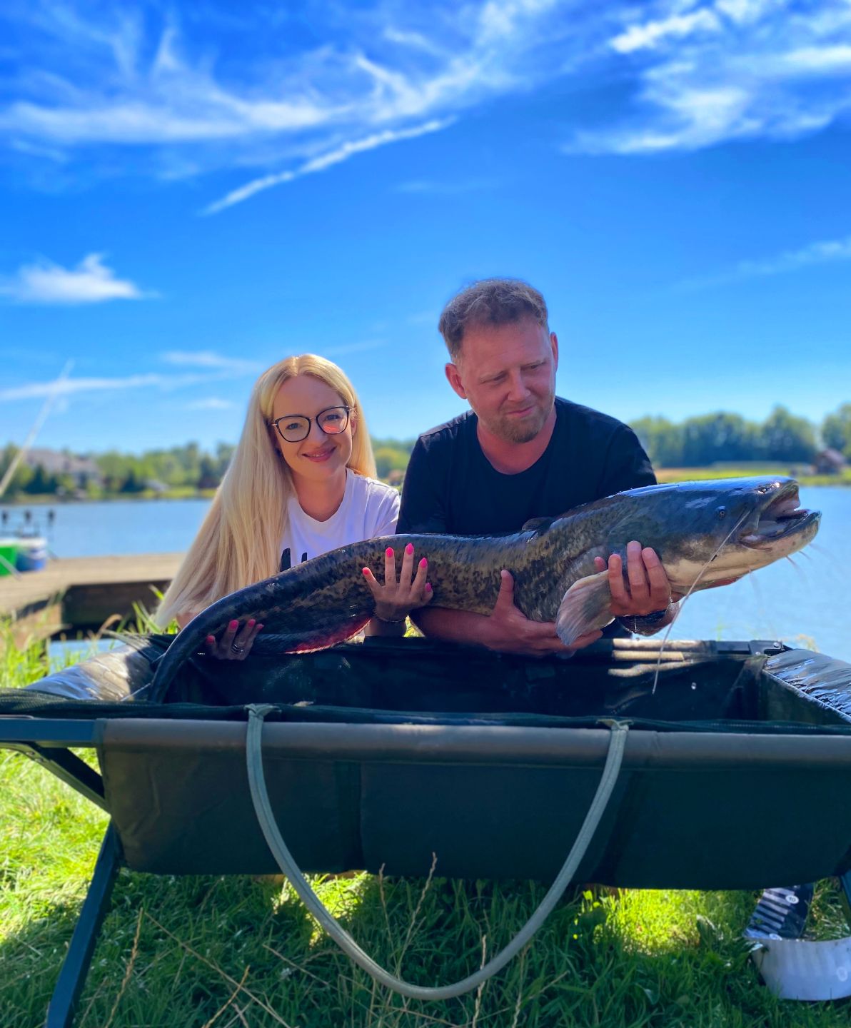 Doktor Krystian Dudek z żoną i ogromną rybą
